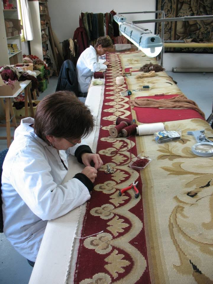 Restauratrices au travail sur un tapis d’Aubusson